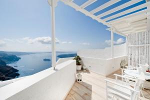 a white house with a view of the ocean at Santorini Roses Suites in Imerovigli