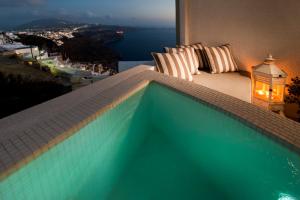 a swimming pool with a view of the ocean at Santorini Roses Suites in Imerovigli