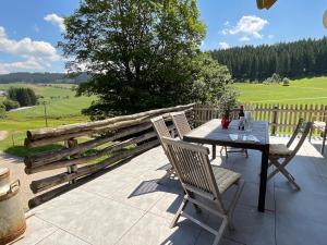 a table and chairs on a patio with a fence at Danielenhof1701, Ferienwohnung Bruckbach in Breitnau