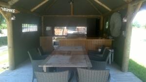 a wooden table and chairs in an outdoor kitchen at Ferme de la Naverie wi - holiday home for 2 persons in Celles