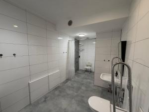 a white bathroom with two sinks and a toilet at WiLDBED DE Mitte in Bad Wildbad