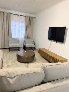 a living room with a couch and a flat screen tv at Vellora Haus in Burgersfort