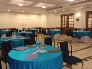 une grande chambre avec des tables et des chaises bleues dans l'établissement Hotel Yuvraj, à Vadodara