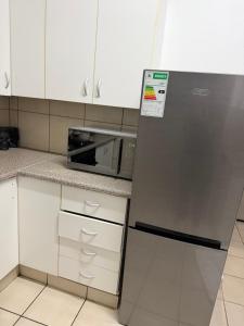 a kitchen with a refrigerator and a microwave at Vellora Haus in Burgersfort