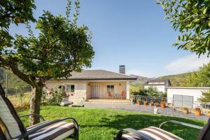 a house with a yard with chairs in front of it at Casa Outeiro in Encinedo