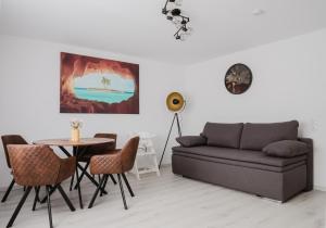 a living room with a couch and a table and chairs at Kokett Apartment in Neu-Ulm