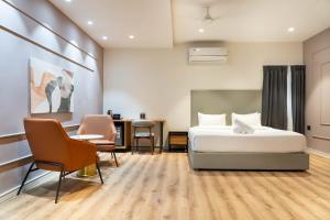 a hotel room with a bed and a desk and chairs at Trunk and Trolley, Gachibowli, A Luxury Boutique Hotel, Hyderabad in Hyderabad +86 photos