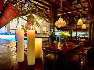 a dining room with a table and two white candles at surf dom hotel & restaurants in Ahangama