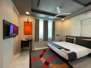 a bedroom with a large bed and a flat screen tv at Hotel Manomay in Nagpur