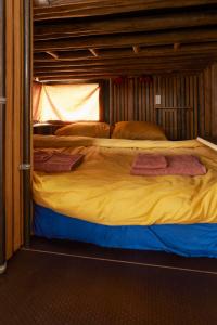 a bunk bed with yellow sheets and pillows on it at Glampervan Rietje in Den Bosch
