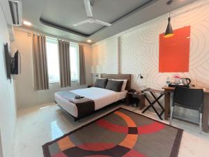 a bedroom with a bed and a table and a desk at Hotel Manomay in Nagpur +22 photos