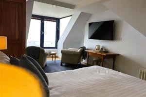 a hotel room with a bed and a desk and a tv at The Waterfront Hotel in Baltimore