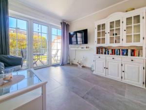 a living room with white cabinets and a large window at Strandkrabbe in Greetsiel