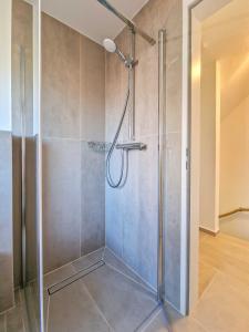 a shower with a glass door in a bathroom at Strandkrabbe in Greetsiel +24 photos