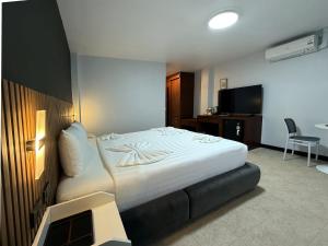 a hotel room with a bed and a television at Karon Place in Karon Beach