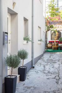two potted plants sitting on the side of a building at Apartments and room Maressa Centar in Vodice