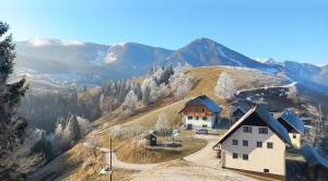 a house on top of a hill with mountains in the background at Apartmaji Peternelj in Železniki