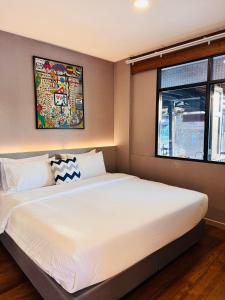 a bedroom with a large white bed with a window at Little Bangkoknoi in Ban Bang Si Thong +116 photos