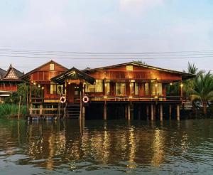 a house on a dock on a body of water at Little Bangkoknoi in Ban Bang Si Thong