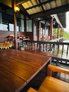 a wooden table and chairs on a porch at Little Bangkoknoi in Ban Bang Si Thong