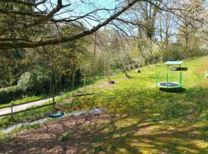 a park with a swing set in the grass at Les Glycines Gîtes - Les Petites Pierres gîte - shared solar heated pool - garden spa - small dogs welcome in Vernoux-en-Gâtine