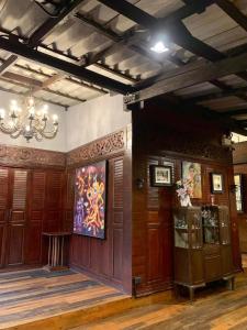 a room with wood paneling and a chandelier at Little Bangkoknoi in Ban Bang Si Thong