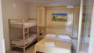 a small room with two bunk beds and a mirror at Hotel la Praia in Zambrone +34 photos