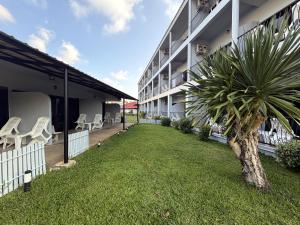 a courtyard of a building with chairs and a palm tree at Karon Place in Karon Beach