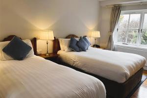 two beds in a bedroom with two lamps and a window at The Waterfront Hotel in Baltimore