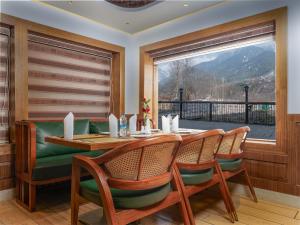a dining room with a table and chairs and a window at The Harmukh Hills in Batakūt