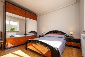 a bedroom with two beds and a large mirror at Casa Outeiro in Encinedo