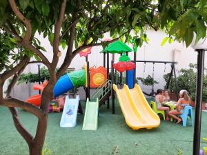 a playground with a slide and children sitting at Hotel la Praia in Zambrone