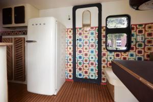 a kitchen with a refrigerator in a train car at Glampervan Julietta in Den Bosch +7 photos