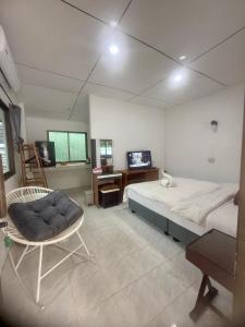 a bedroom with a bed and a chair and a television at Best Beach Bungalows in Chaweng