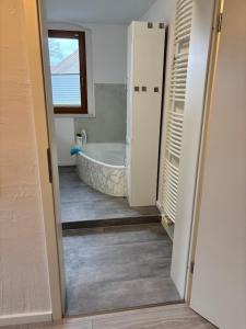 a bathroom with a tub and a bath tub at gemütliche Ferienwohnung in Burgstaedt