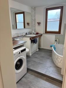 a bathroom with a washing machine and a bath tub at gemütliche Ferienwohnung in Burgstaedt