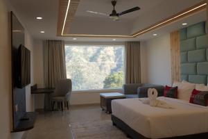 a bedroom with a bed and a couch and a television at Parag Resort Kasauli in Solan +9 photos