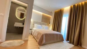 a bedroom with a large bed and a mirror at Hotel Metali - City Centre in Sarandë