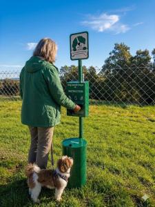a woman standing next to a trash can with a dog at Hoteles Desconecta2 by Vicoba in Monesterio