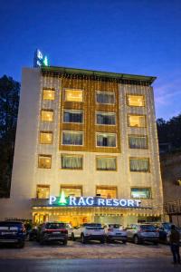 a large hotel with cars parked in front of it at Parag Resort Kasauli in Solan