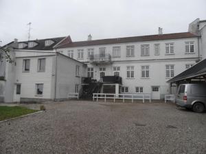 a large white building with a van parked in front of it at Gamle Præstegård, viceværtlejlighed in Årup
