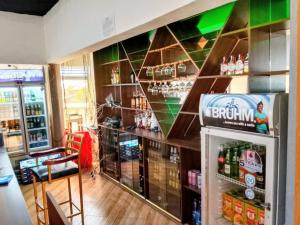 a bar with a refrigerator and a shelf with drinks at Himaya Garden in Lanet