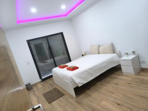 a bedroom with a white bed with red shoes on it at Residência SB in Odivelas +7 photos