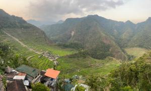 an aerial view of a mountain valley with a village at Overlooking the Rice Terraces in Banaue +8 photos