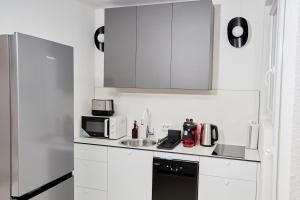 a white kitchen with a sink and a refrigerator at 2 OG HbF Wuppertal DomusKushal in Wuppertal