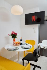 a dining room with a white table and yellow chairs at 2 OG HbF Wuppertal DomusKushal in Wuppertal
