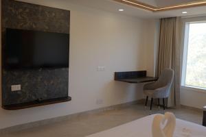 a hotel room with a large flat screen tv on the wall at Parag Resort Kasauli in Solan