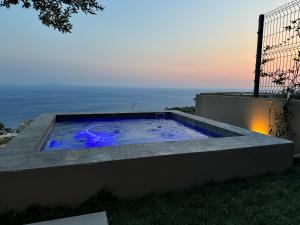 a swimming pool on the side of a house with the sunset at Hotel Amare in Palasë