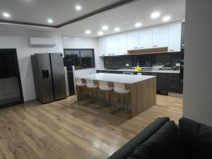 a kitchen with a large island with bar stools at Residência SB in Odivelas
