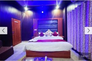 a bedroom with a large bed with purple lighting at Hotel moon in Pāonta Sāhib